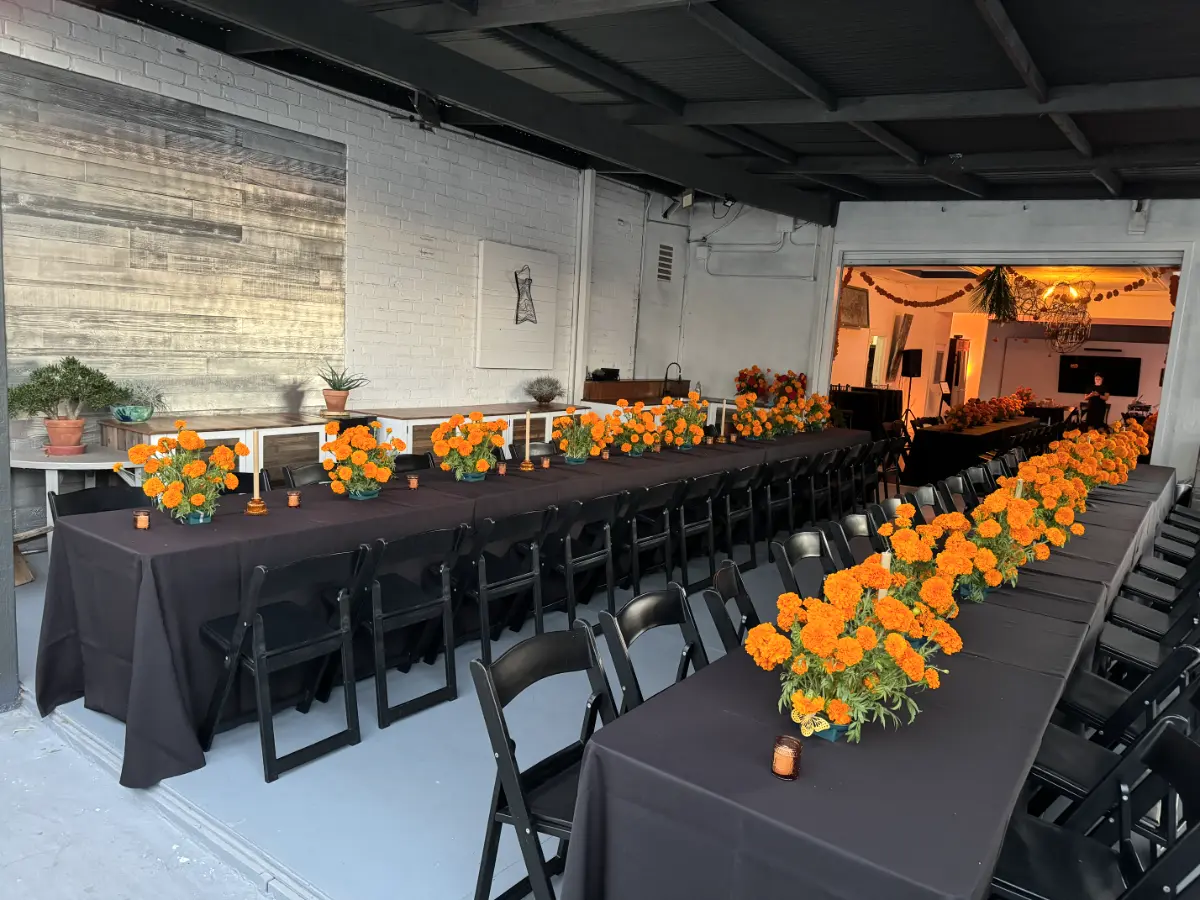 Elegant outdoor dining setup with marigold floral centerpieces at Art and Space LA